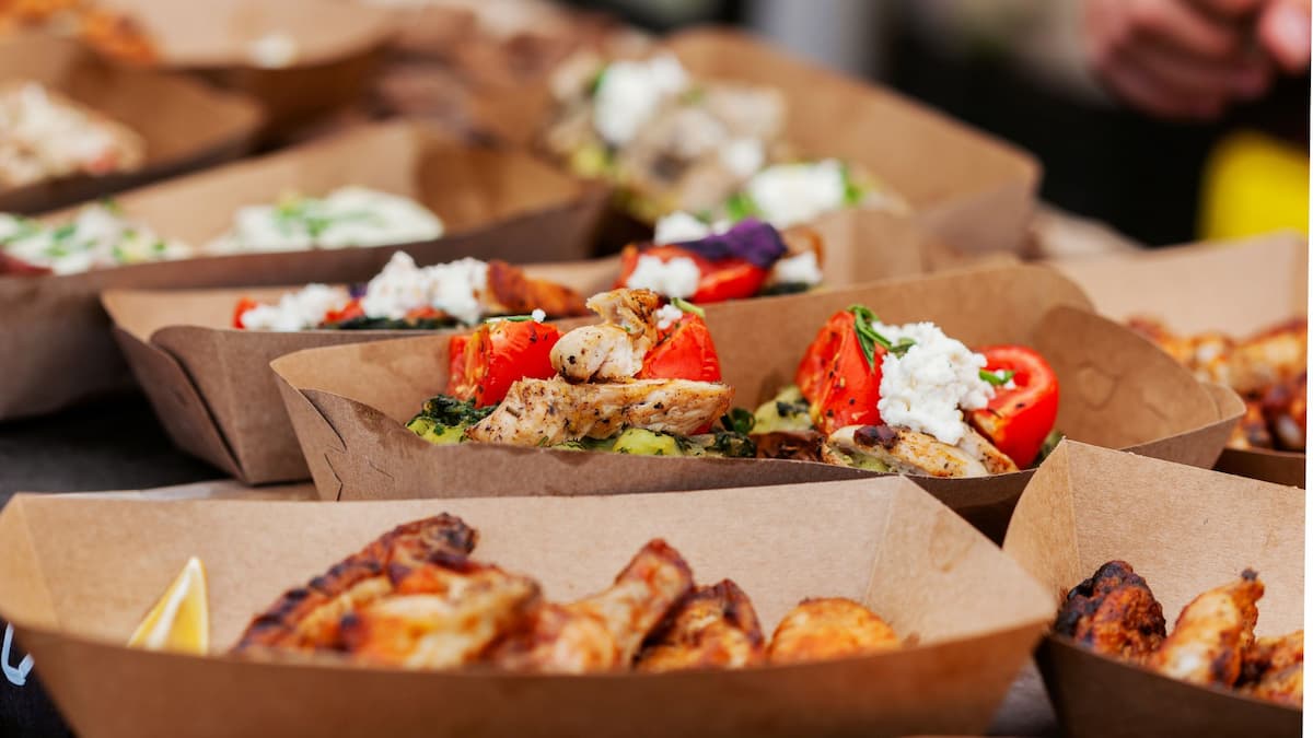 Envases de cartón kraft con comida preparada para catering y eventos
